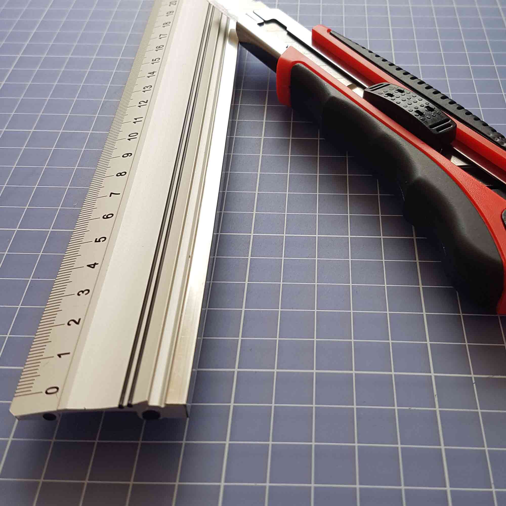 Perfekte Kombi: Schneidelineal mit Cutter für saubere Kanten Aluminium-Schneidelineal neben Cutter-Messer auf Werkbank