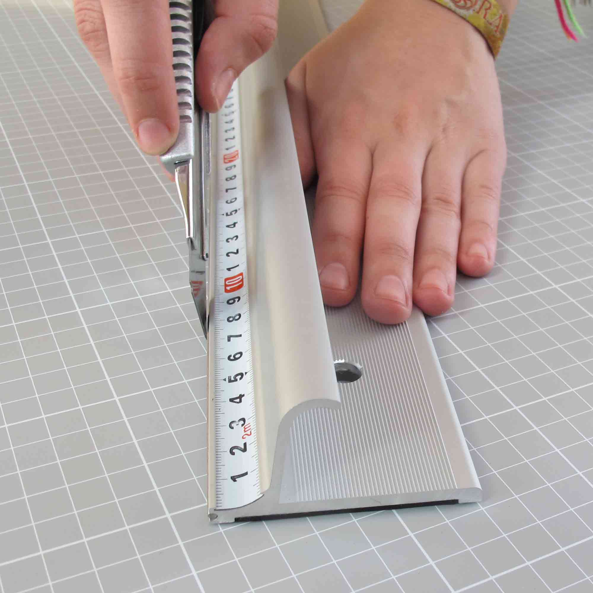 Hand mit FIXUM Sicherheitslineal in ergonomischer Haltung – entspanntes Schneiden ohne Kraftaufwand Ergonomisches Sicherheitslineal mit rutschfester Griffzone